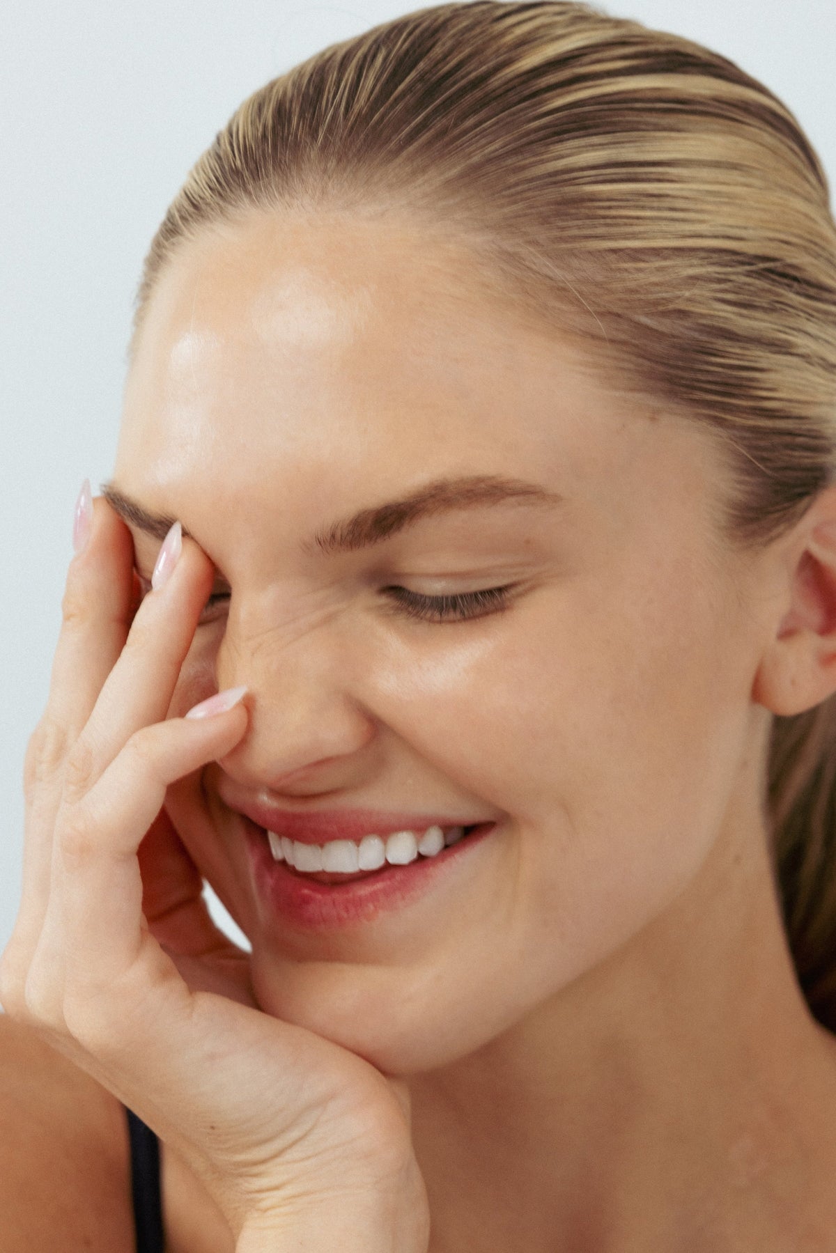 Woman with clear skin touching face after acne treatment at NYC clinic