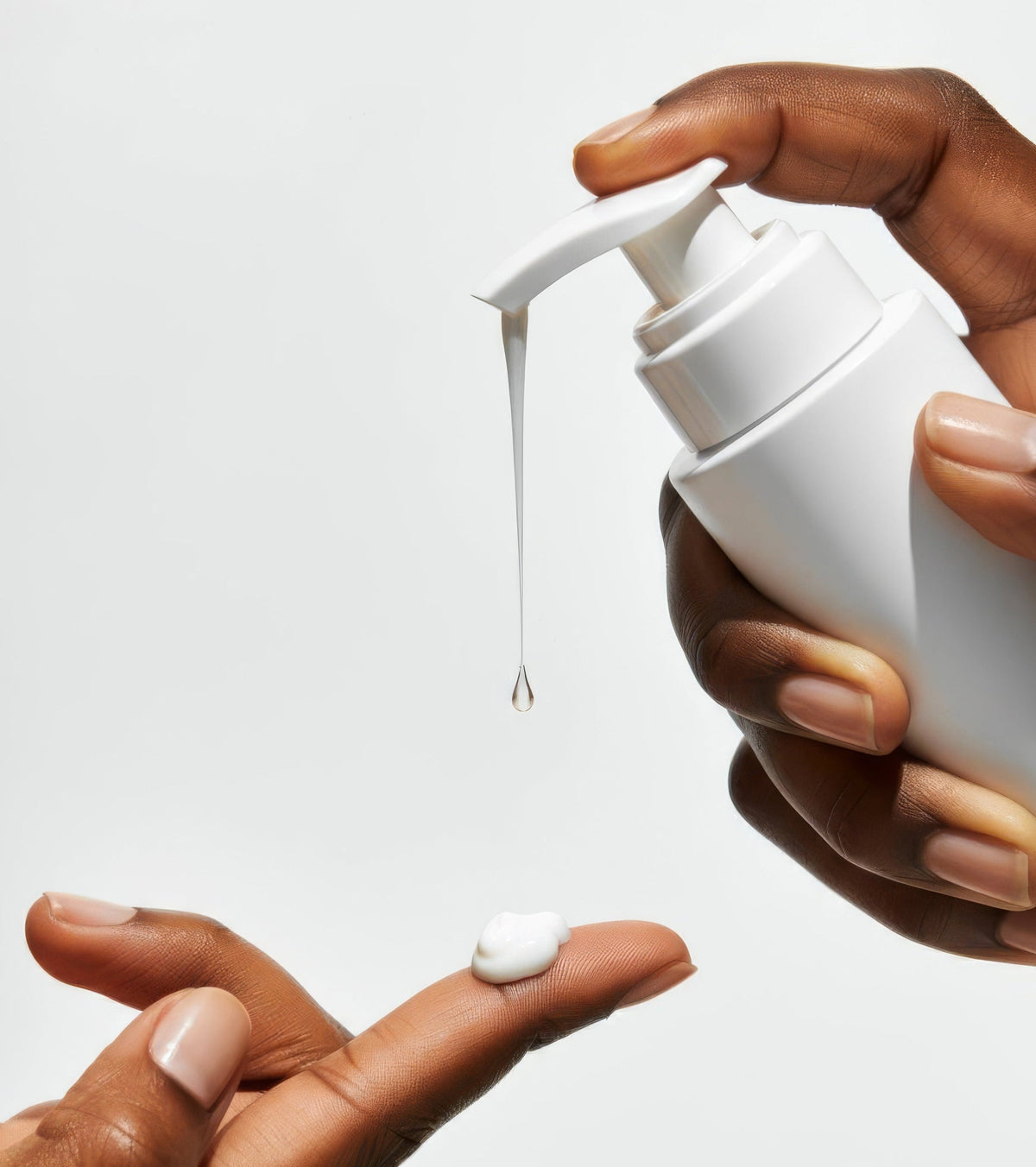 Hands dispensing white skincare cream from a pump bottle against a white background, representing acne peel product application